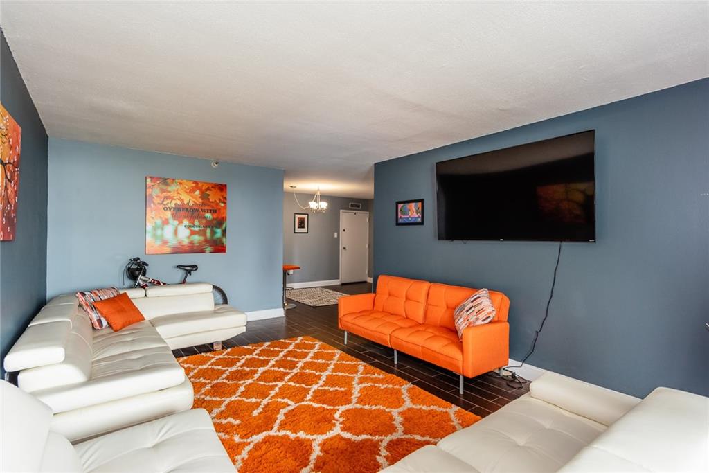 375 Ralph McGill Boulevard Northeast, Unit 1701 Atlanta, GA 30312 - Photo 16 of 33 a living room with blue couches and a flat screen tv