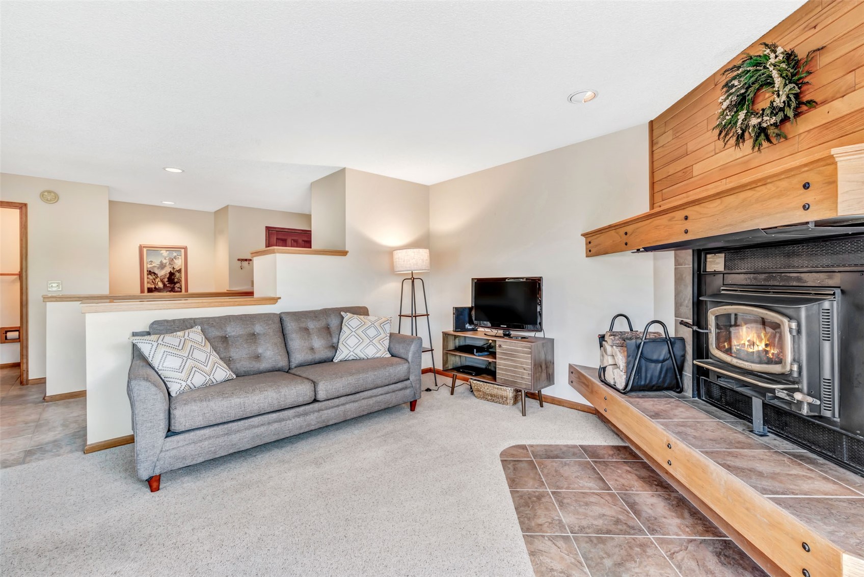 1675 Ranch Road, Unit 411 Steamboat Springs, CO 80487 - Photo 5 of 48 Carpeted living room featuring wood walls and a wood stove
