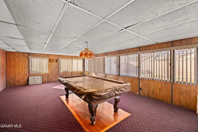 a room with furniture pool table and windows