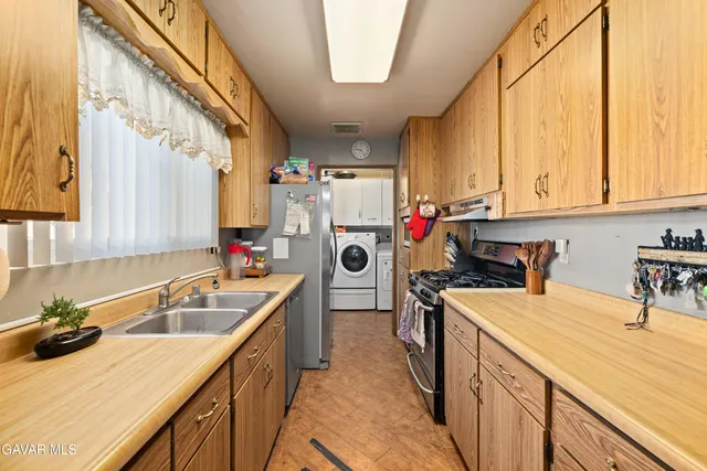 a kitchen with a sink a stove and cabinets
