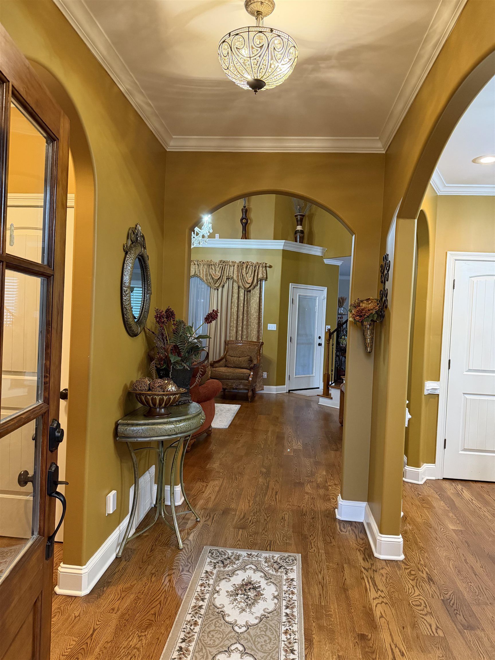 7284 Bucknell Road Millington, TN 38053 - Photo 4 of 24 Hardwood flooring, arched doorways, crown molding, decorative lighting fixture, and white trim