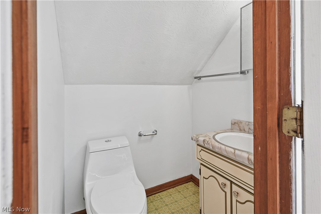 1286 Deforest Road Southeast Warren, OH 44484 - Photo 17 of 27 Compact powder room featuring a contemporary white toilet, vanity with integrated sink and patterned countertop, and mirrored medicine cabinet