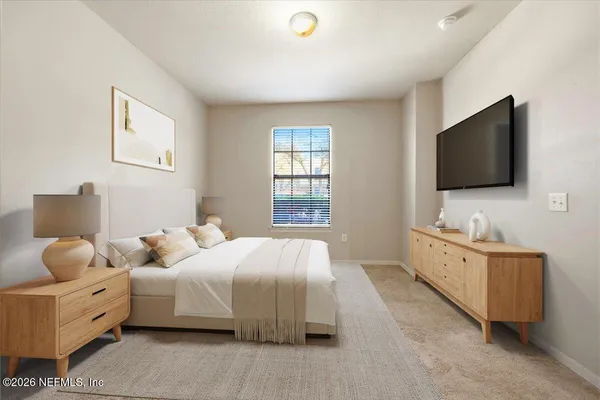 a bedroom with bed and flat tv screen on the dresser