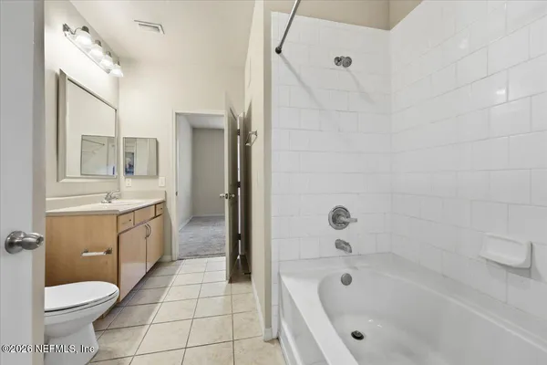 a bathroom with a granite countertop toilet a sink and bathtub