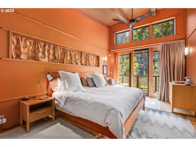 a bedroom with a bed and a large window