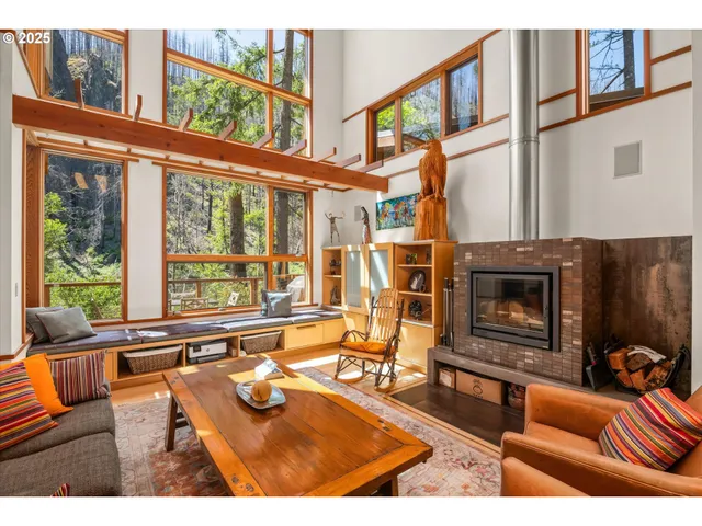 a living room with furniture a fireplace and a large window