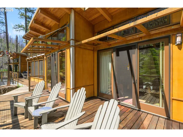 a view of a patio with table and chairs with wooden floor and fence