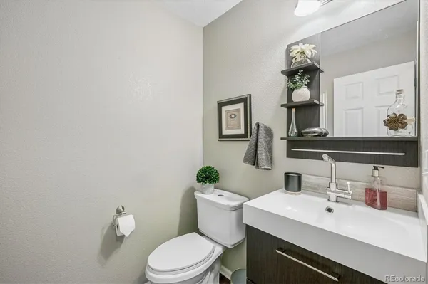 a bathroom with a sink vanity mirror and toilet