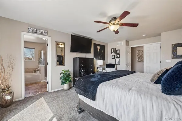 a spacious bedroom with a bed and a flat screen tv