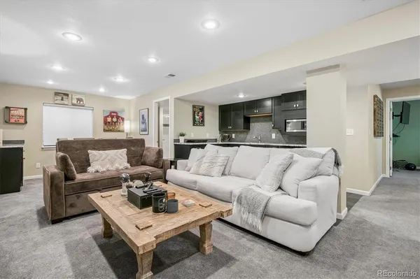 a living room with furniture and a view of kitchen