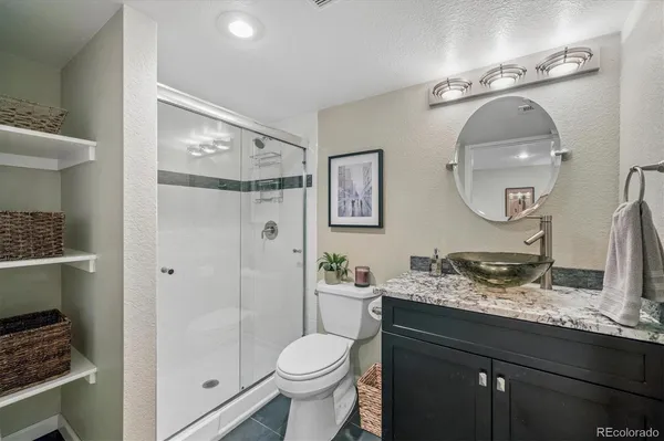 a bathroom with a granite countertop sink toilet and shower