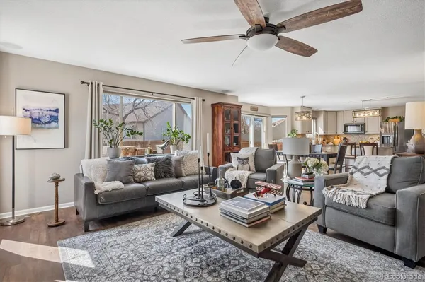a living room with furniture a rug potted plant and a large window
