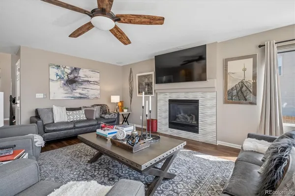 a living room with furniture a flat screen tv and a fireplace