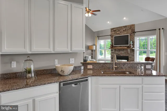 a kitchen with granite countertop a sink stainless steel appliances and cabinets