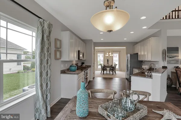 a kitchen with sink refrigerator dining table and chairs