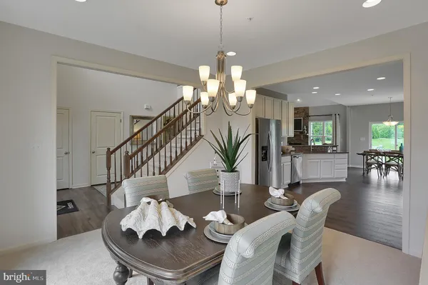 a living room with furniture a dining table and a chandelier