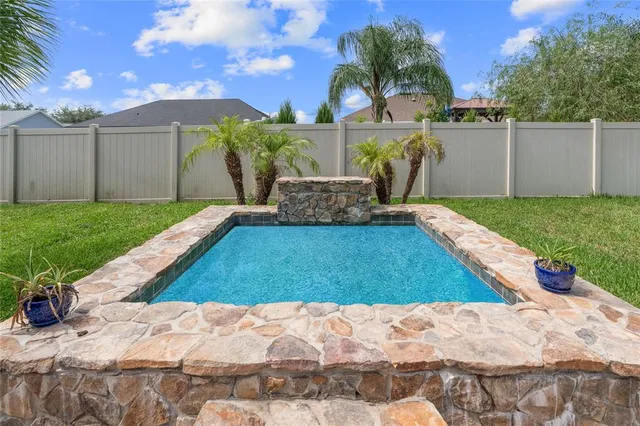 a backyard of a house with dining table and chairs