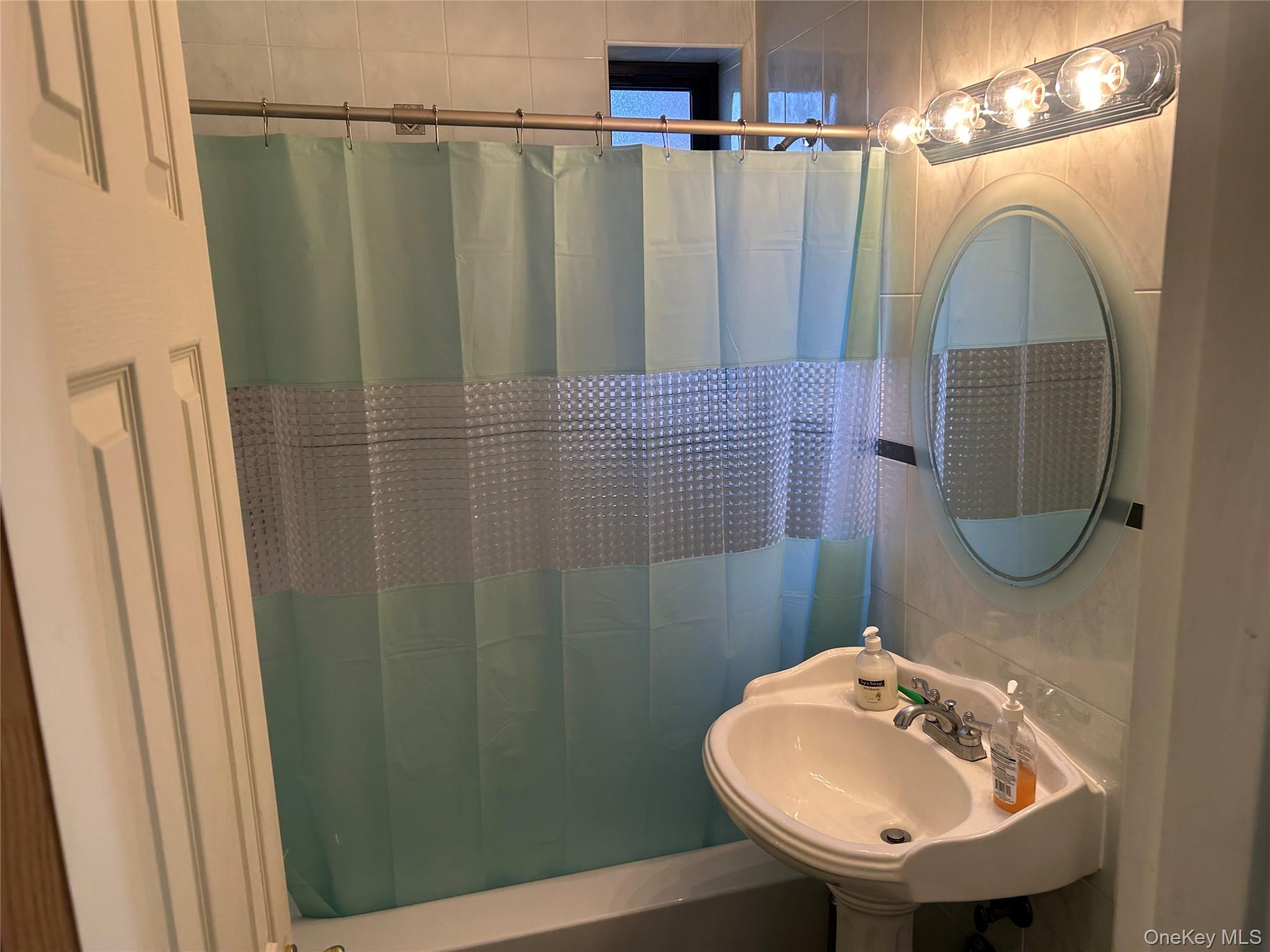 83-20 98th Street, Unit 5J Queens, NY 11421 - Photo 16 of 17 a bathroom with a sink a mirror and vanity