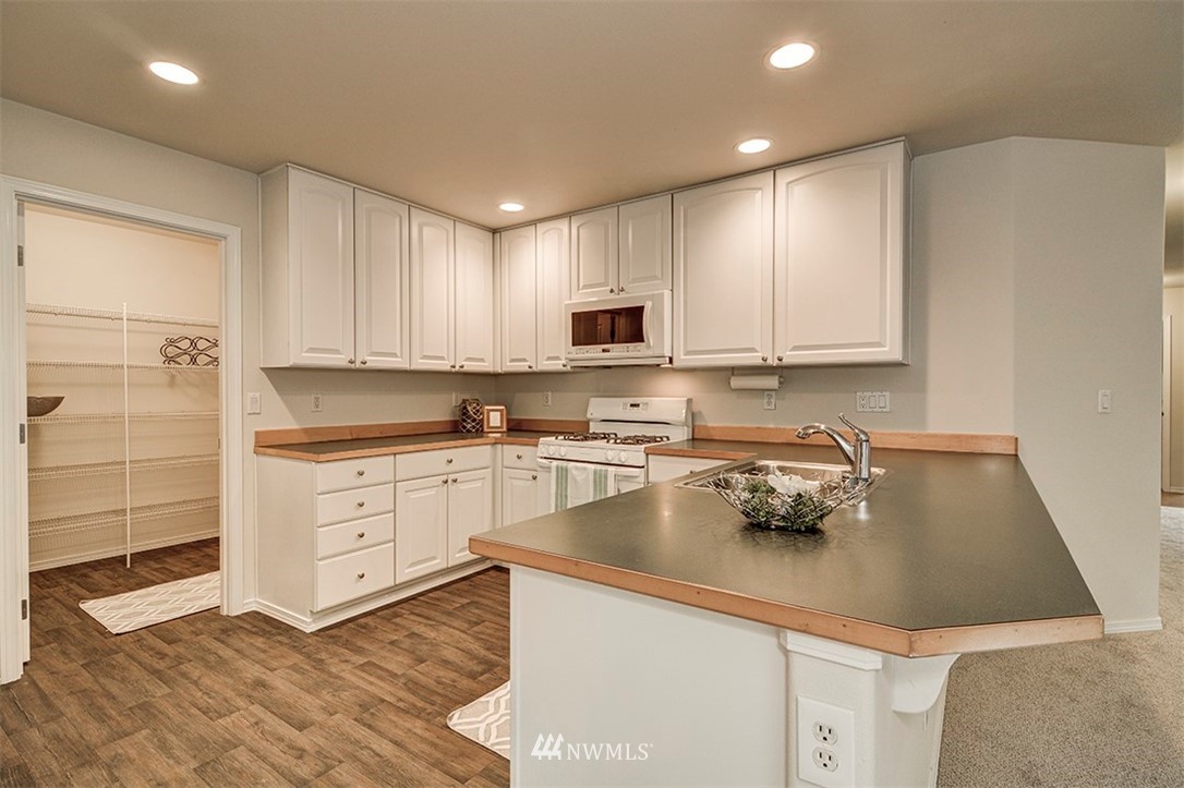 2402 Southeast 2nd Place Renton, WA 98056 - Photo 4 of 40 a kitchen with a sink cabinets and wooden floor