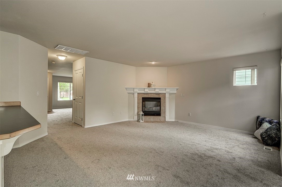 2402 Southeast 2nd Place Renton, WA 98056 - Photo 8 of 40 a view of an empty room with a fireplace and a window