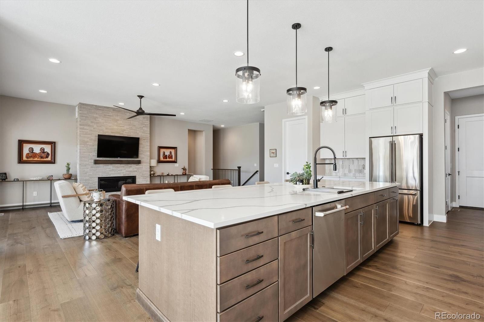 7334 Canyonpoint Road Castle Pines, CO 80108 - Photo 15 of 50 a large kitchen with kitchen island a sink a counter space and stainless steel appliances