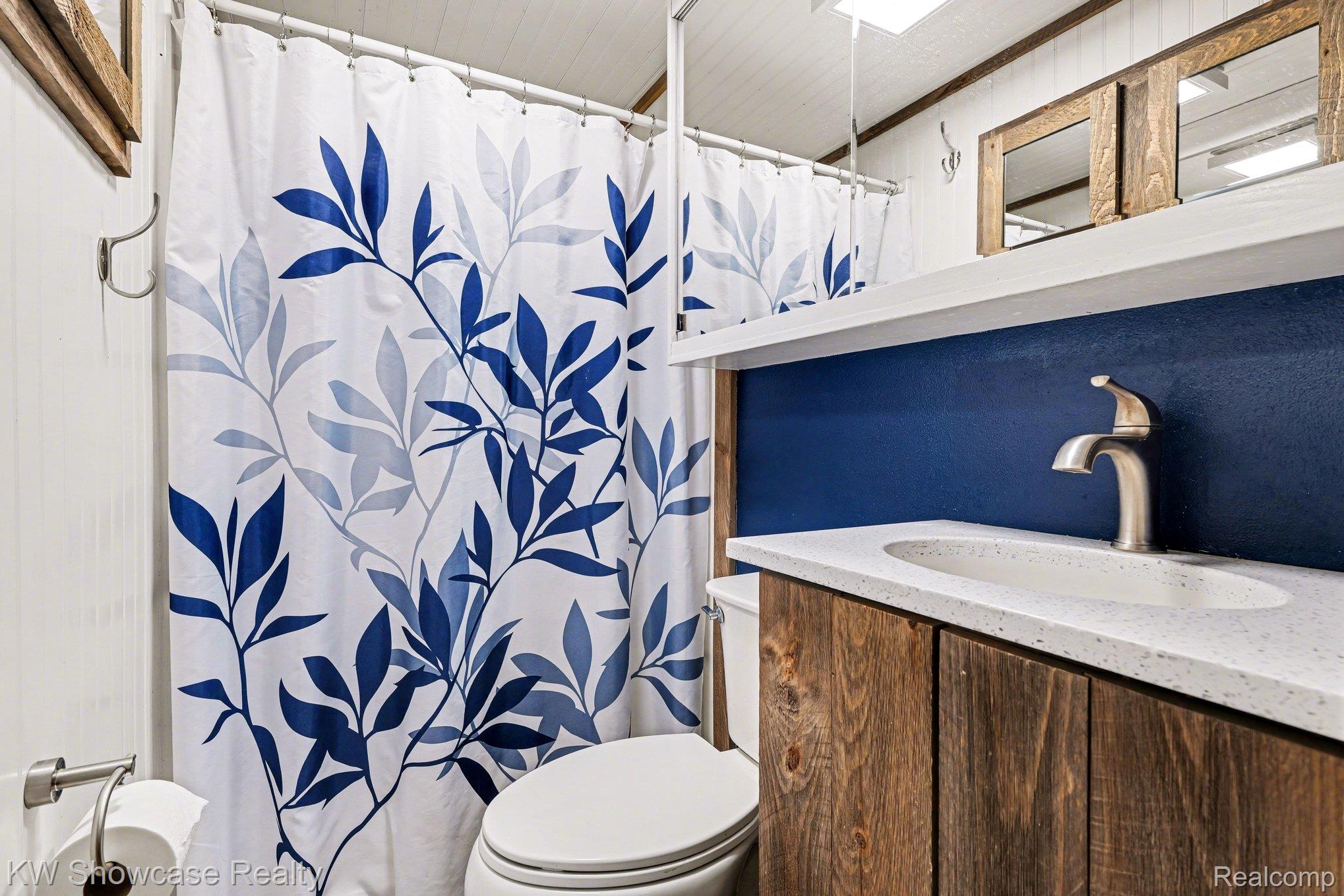 1951 East Kneeland Road Fairview, MI 48621 - Photo 16 of 46 Full bathroom with vanity and a shower with shower curtain