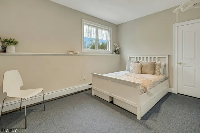 a white bed sitting in a bedroom next to a window
