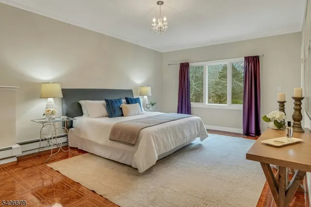 a bedroom with a large bed and a chandelier