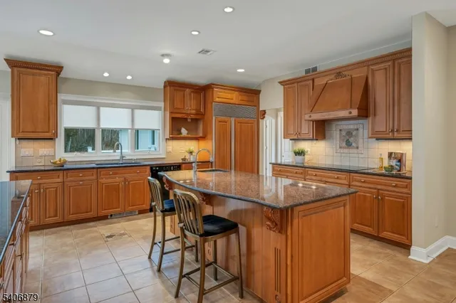 a kitchen with stainless steel appliances granite countertop a stove a sink a refrigerator and cabinets