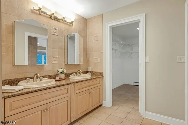 a spacious bathroom with a double vanity sink a mirror and a