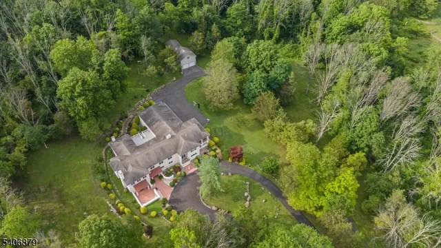 an aerial view of residential house with outdoor space and trees all around