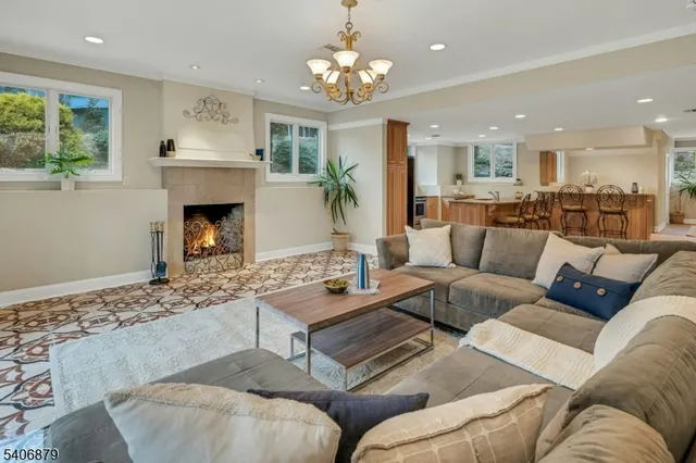 a living room with furniture a fireplace and a chandelier