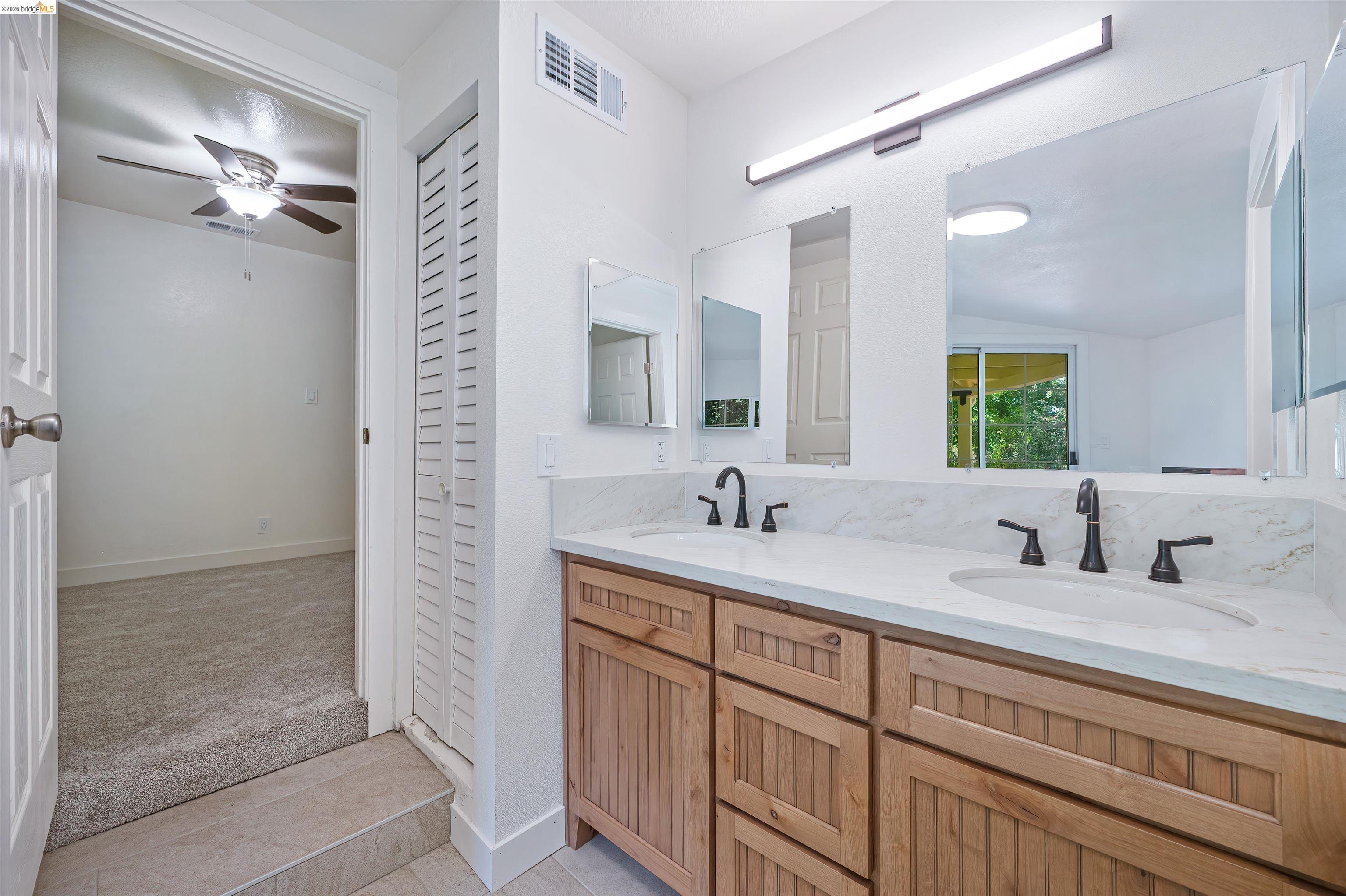 10474 Sheldon Road Elk Grove, CA 95624 - Photo 36 of 83 Dual vanity with integrated sinks, light-toned stone-finish countertop, and black fixtures