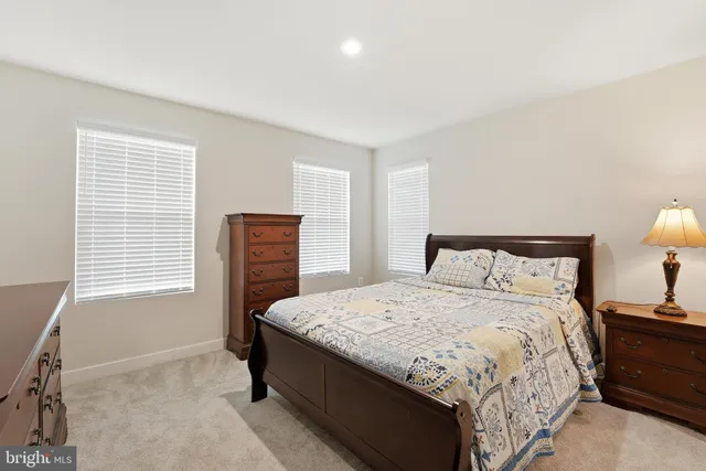 a bedroom with a bed and a lamp on dresser