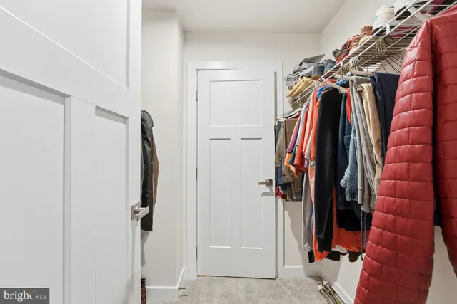 a view of walk in closet with clothes
