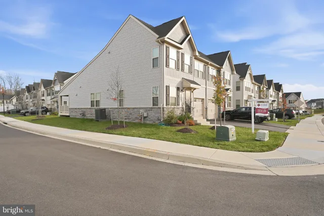 a view of a white house with a yard and plants