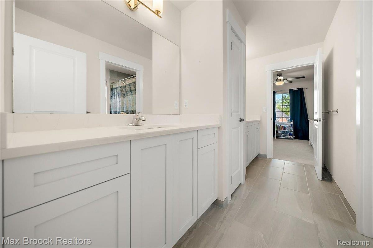 1942 Nottingham Drive Rochester, MI 48307 - Photo 57 of 97 Spacious bathroom vanity featuring light gray cabinetry, a white countertop, and a single-basin sink with a chrome faucet