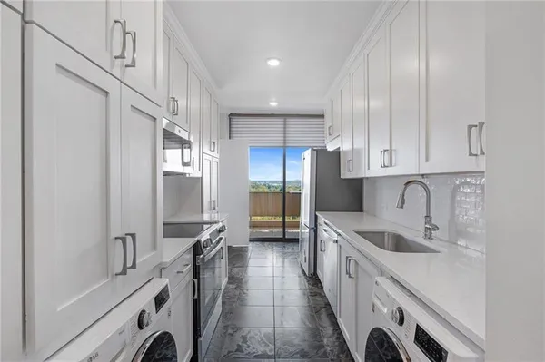 a kitchen with granite countertop a sink stainless steel appliances and cabinets