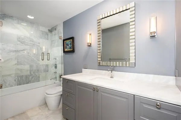 a bathroom with a sink a toilet and shower