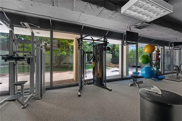 a view of a room with gym equipment and floor to ceiling window