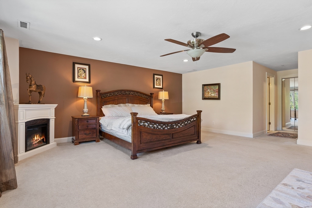 215 Rangeway Road, Unit 32 Billerica, MA 01862 - Photo 19 of 39 a bedroom with a bed ceiling fan and a fireplace