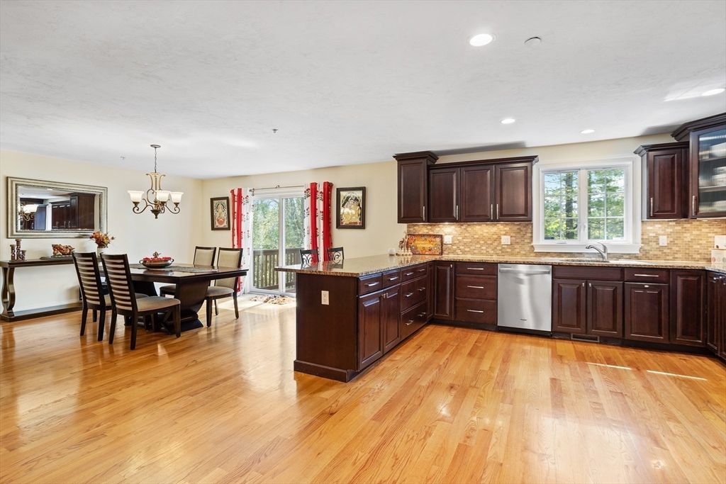 215 Rangeway Road, Unit 32 Billerica, MA 01862 - Photo 8 of 39 a kitchen with stainless steel appliances kitchen island granite countertop a stove top oven a sink a dining table and chairs