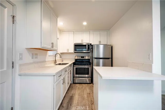 a kitchen with a sink a microwave a stove and refrigerator