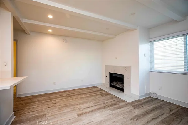 a view of empty room with wooden floor and fireplace