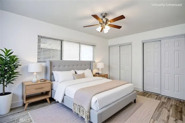 a bedroom with a large bed a potted plant and a window