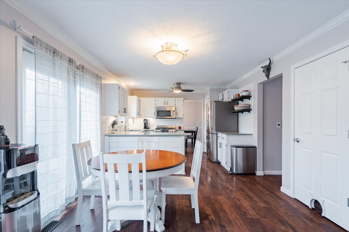 607 Old Farm Road Bloomington, IL 61704 - Photo 13 of 40 a kitchen with a dining table chairs wooden floor and appliances