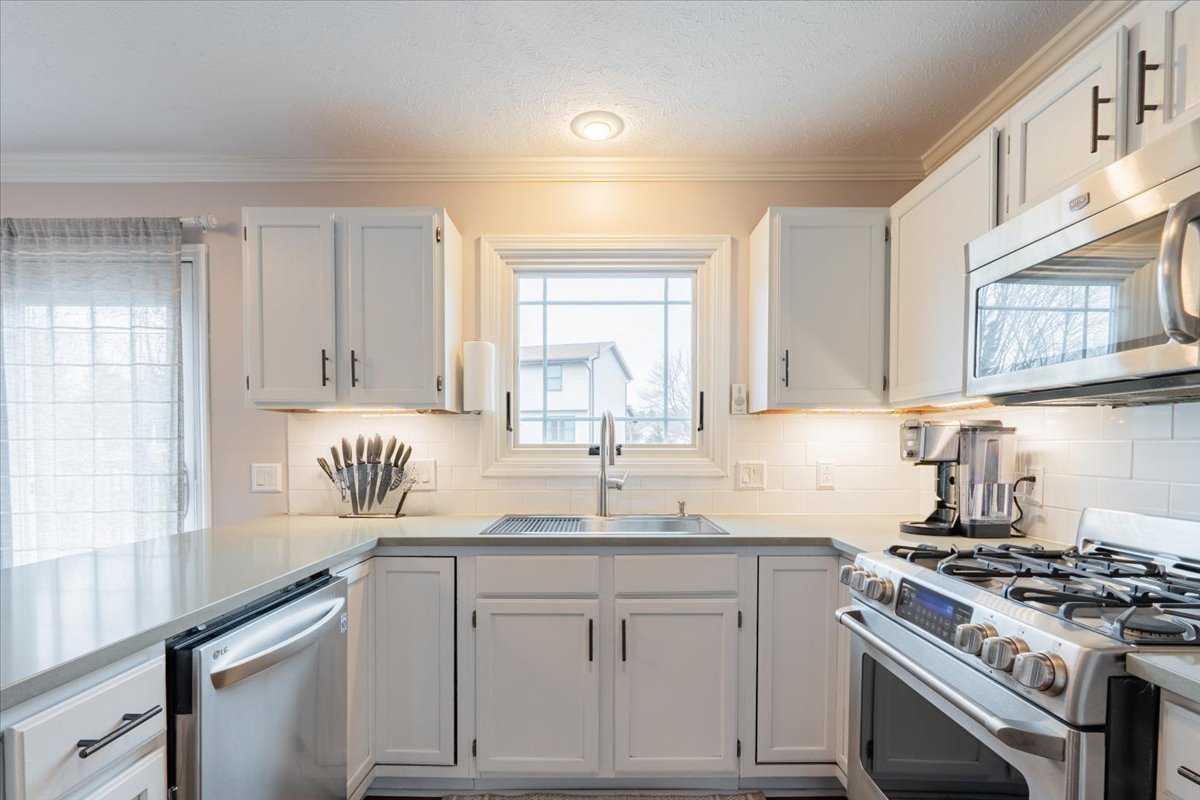 607 Old Farm Road Bloomington, IL 61704 - Photo 16 of 40 a kitchen with stainless steel appliances granite countertop a sink stove and cabinets