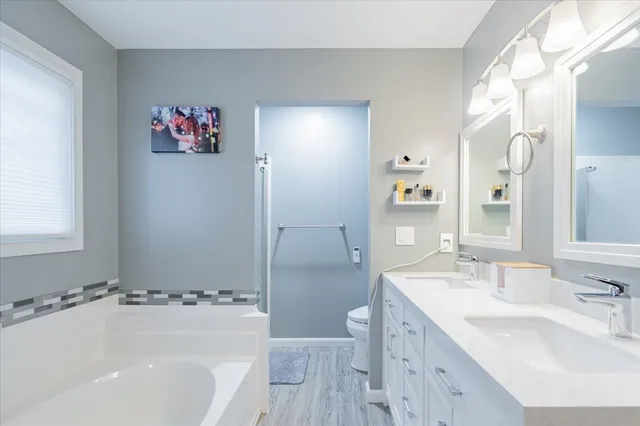 a bathroom with a tub a sink and a large mirror