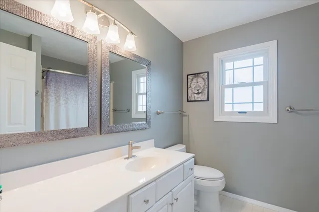 a bathroom with a toilet sink and mirror