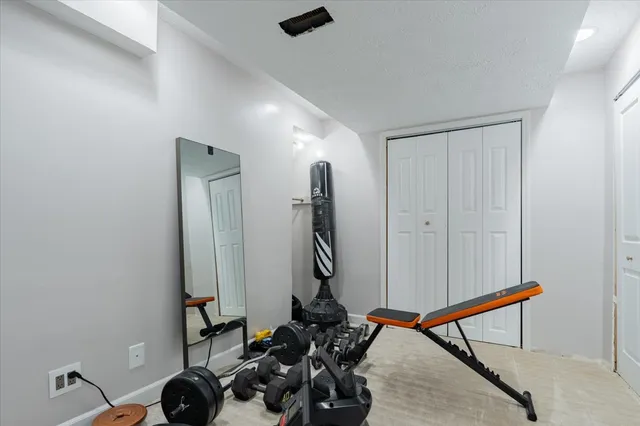 a room with gym equipment and wooden floor